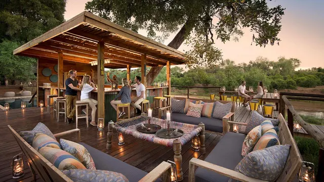 Guests enjoying sundowners at a safari lodge deck bar